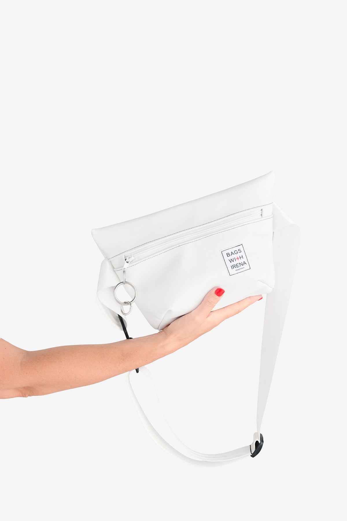 Bag2Back – eine Hand hält die weiße Tasche von unten, der Träger hängt herab