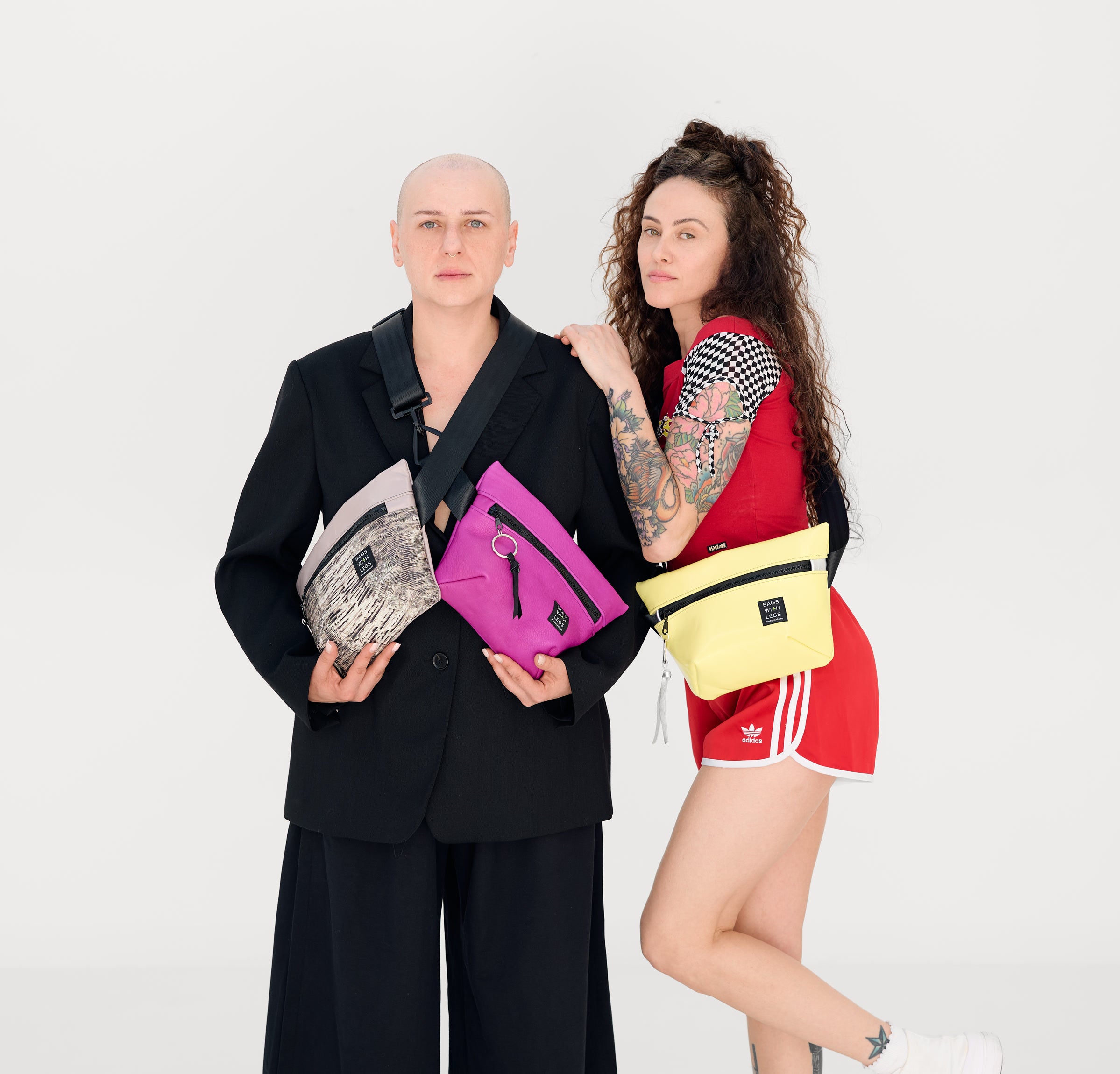 Zwei Personen tragen silberne, pinke und gelbe Taschen von Bags With Legs