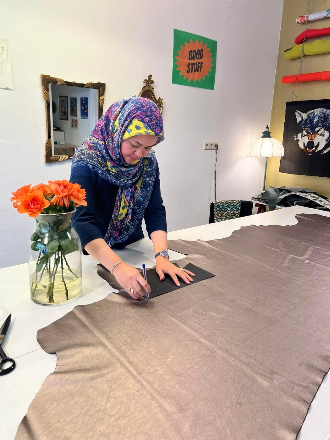Eine Macherin markiert und schneidet braunes Leder am Atelier-Tisch