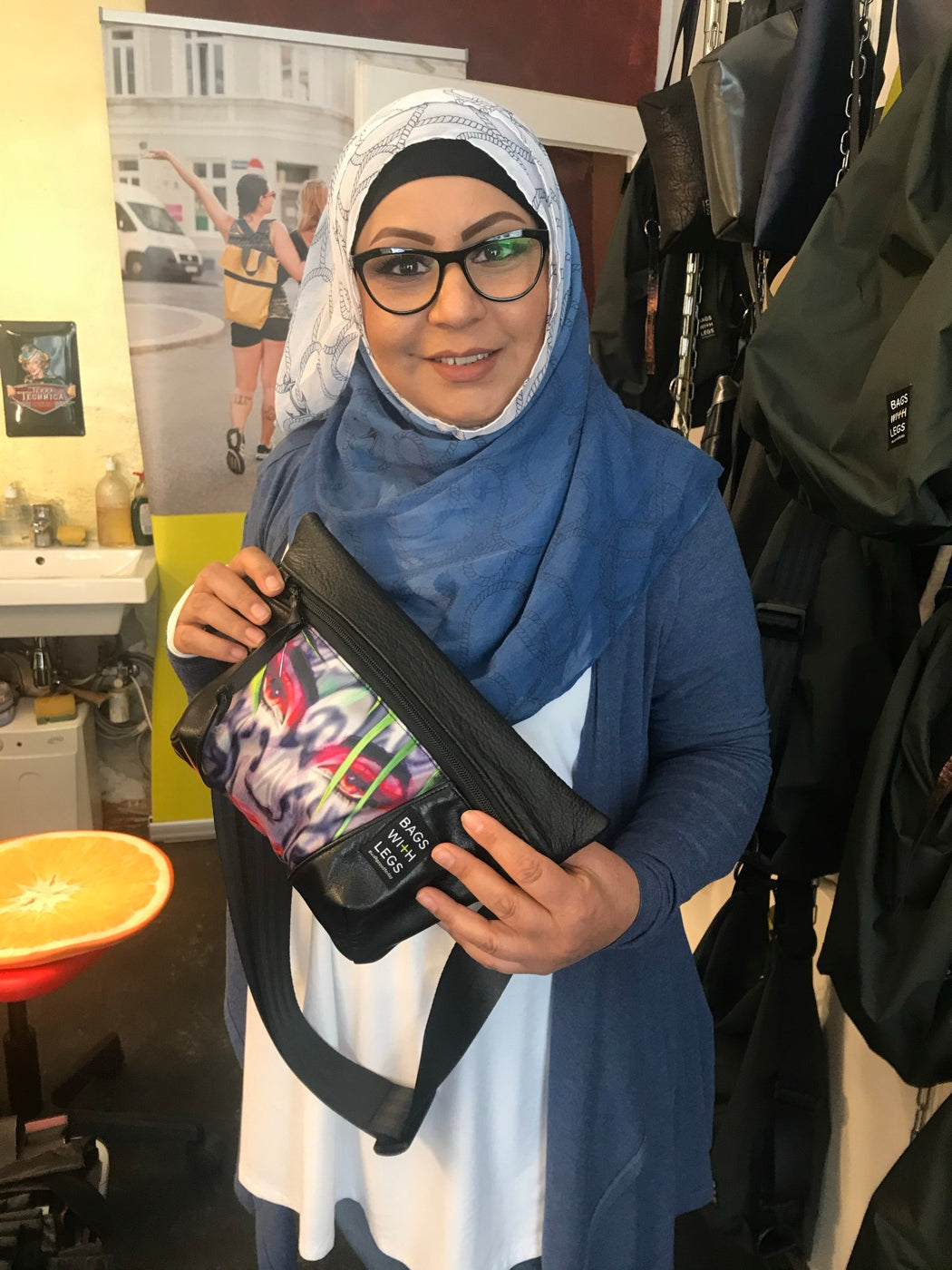 Eine Macherin zeigt eine bedruckte Bags With Legs Tasche im Laden