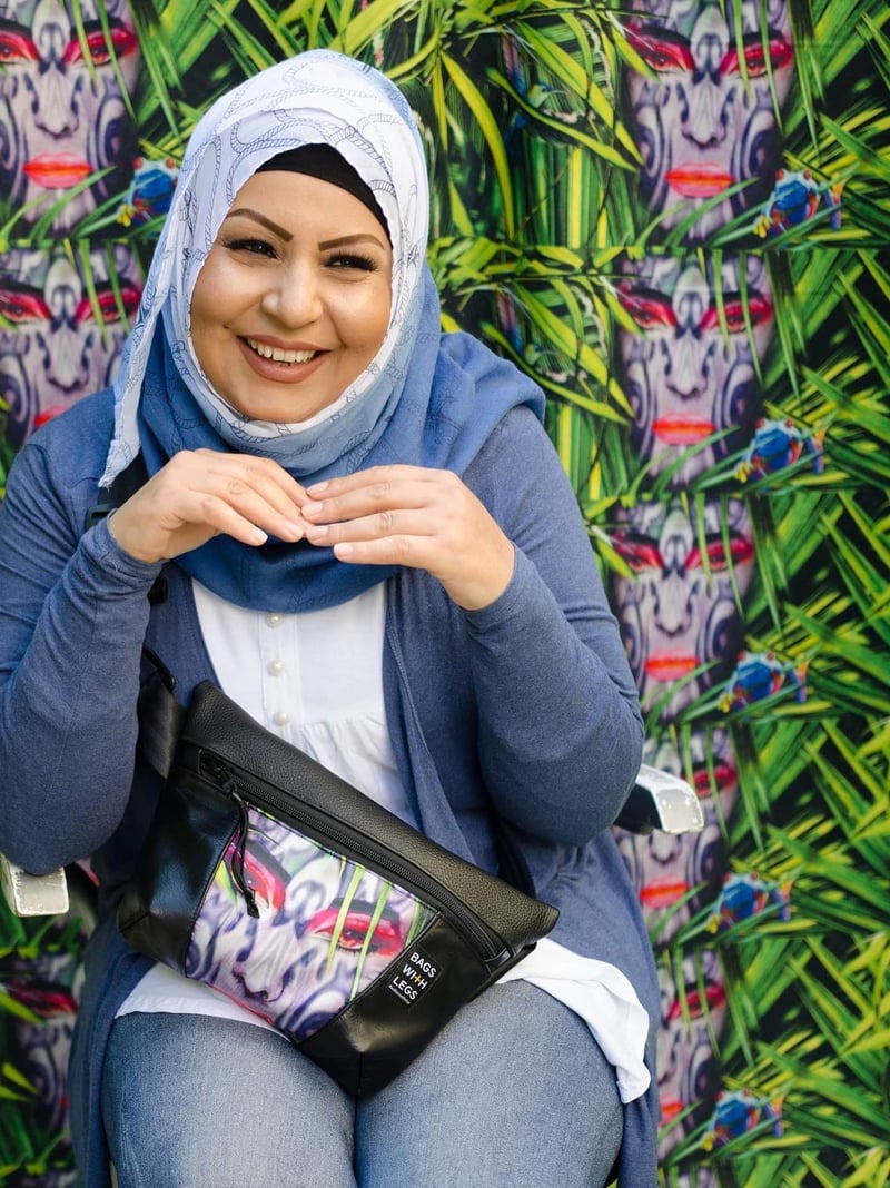 Fahima Sadat mit einer bedruckten Bags With Legs Gürteltasche vor einem Wandbild
