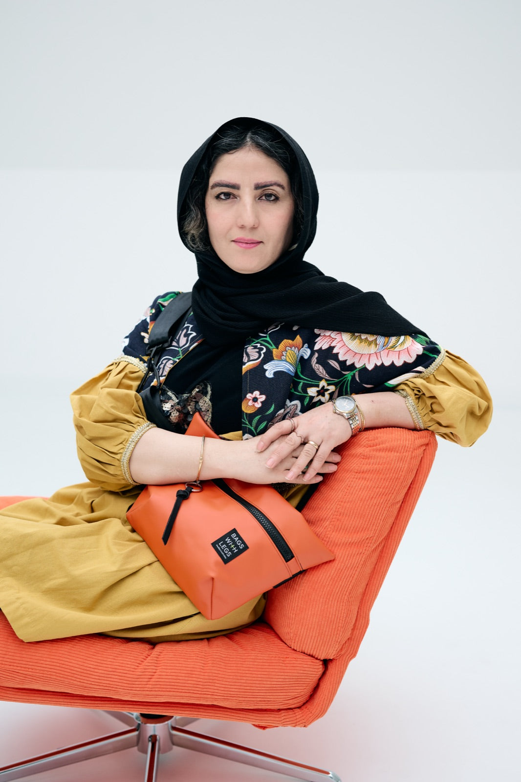 Fatima im Studio mit einer orangen Bags With Legs Tasche